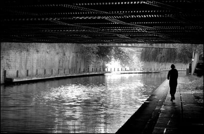 Rear view of man walking in water