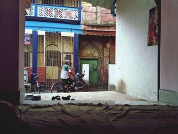 Man sitting at entrance of building