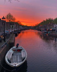 Boats moored at harbor during sunset