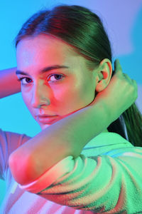 Close-up portrait of young woman with hand in hair 