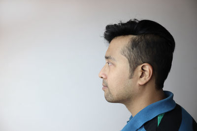 Portrait of young man against white background