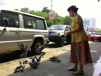 Rear view of woman standing on road