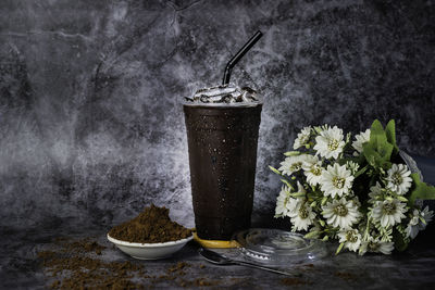 Iced chocolate with ice in the glass there is a drop of water on the side of the glass.