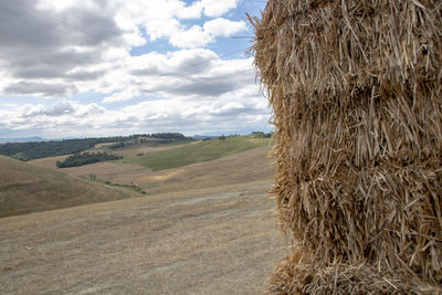 Hay bales on field against sky