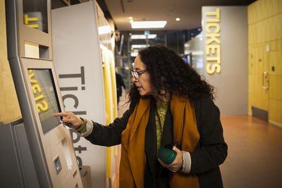 Woman buying tickets in ticket machine