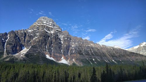 Scenic view of rocky mountains against blue sky