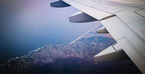 Airplane flying over sea against sky