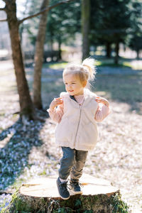 Portrait of cute girl standing in forest