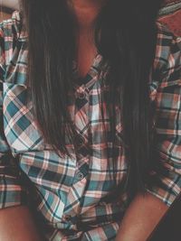 Midsection of woman sitting at home
