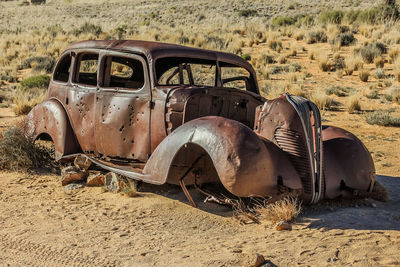 Abandoned vintage car on field