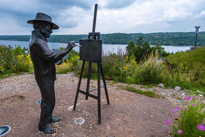 Man standing by lake against sky