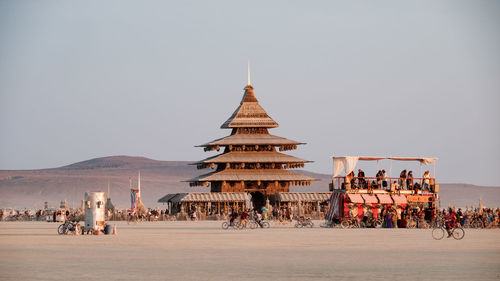 People at temple against clear sky