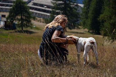 Side view of woman with dog on field