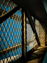 Low angle view of bridge seen through chainlink fence