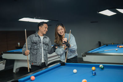 Portrait of woman playing pool