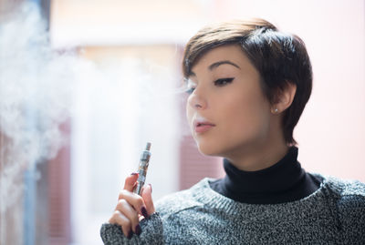 Close-up of young woman with e-cig