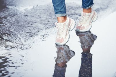 Low section of man standing on puddle