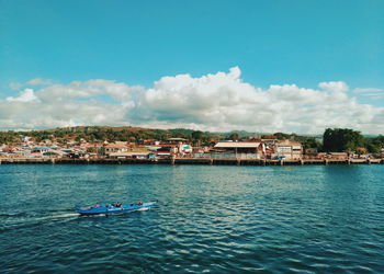 Scenic view of sea by buildings against sky