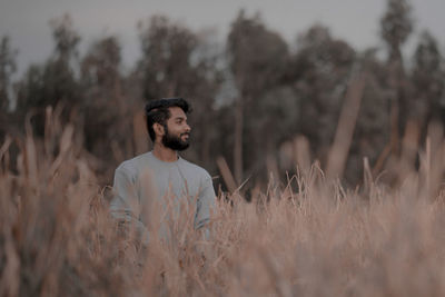 Young man looking away on field