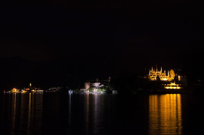 View of illuminated city at waterfront at night