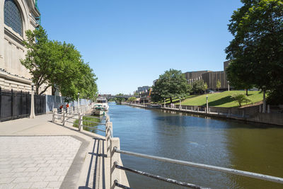 River amidst buildings against clear blue sky