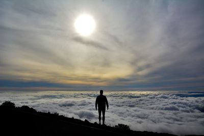 Rear view of silhouette man standing against sky during sunset