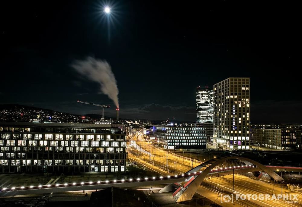 illuminated, night, city, building exterior, architecture, built structure, cityscape, skyscraper, modern, office building, tall - high, city life, sky, tower, urban skyline, capital cities, high angle view, light - natural phenomenon, financial district, residential building