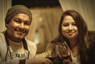 Portrait of smiling young couple toasting wineglasses