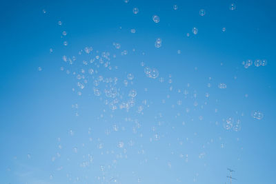 Low angle view of balloons against blue sky