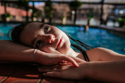 Portrait of woman lying on swimming pool