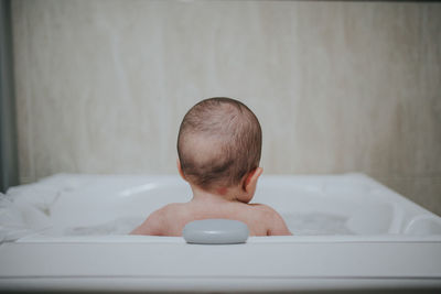 Rear view of baby in bathtub at home