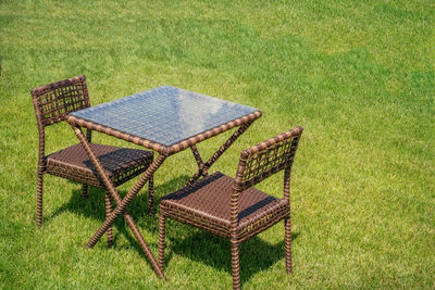 Two empty chairs and one table on the green grass