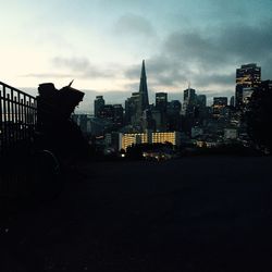 Buildings in city against cloudy sky