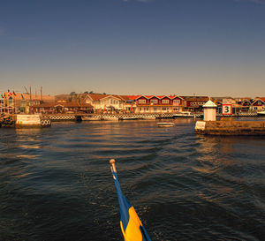 Buildings by sea against clear sky