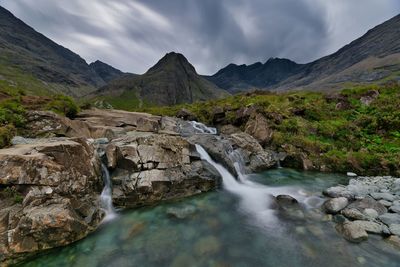 Waterfall and mountains against sky