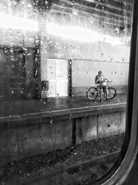 Man seen through wet window