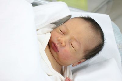 High angle view of baby sleeping in bed