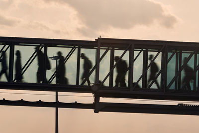 Low angle view of silhouette man standing against railing