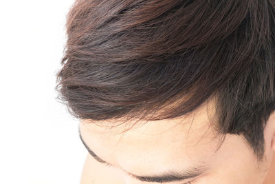 Close-up of woman with hair against white background