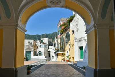 Houses of the village of albori seen from the arch of a church, in the province of salerno.