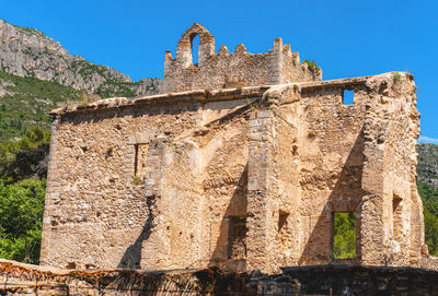 Low angle view of old building against blue sky