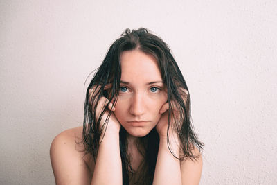 Portrait of beautiful woman against wall