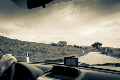 Man driving car on road against sky