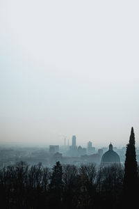 Silhouette trees and buildings against sky
