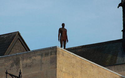 Low angle view of man standing against clear sky