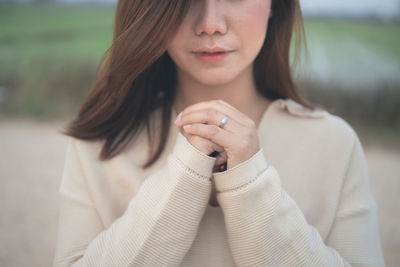 Midsection of beautiful young woman with hands clasped praying