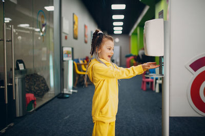 Side view of a smiling girl standing in corridor