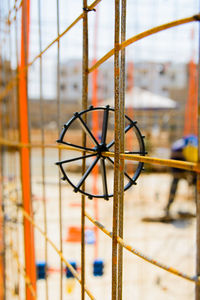 Close-up of wire on metal fence against building