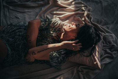 High angle view of woman lying on bed