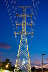 Low angle view of illuminated electricity pylon at night